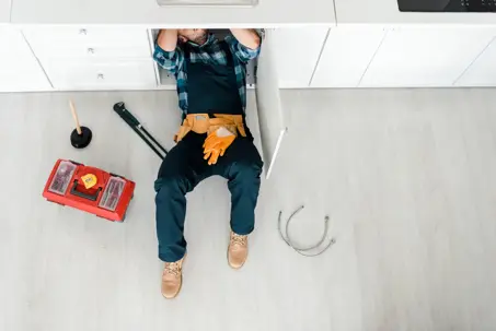plumber working under a sink