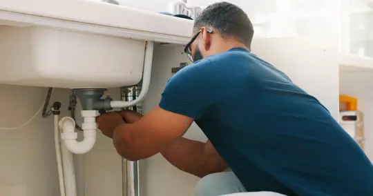 plumber working on a sink